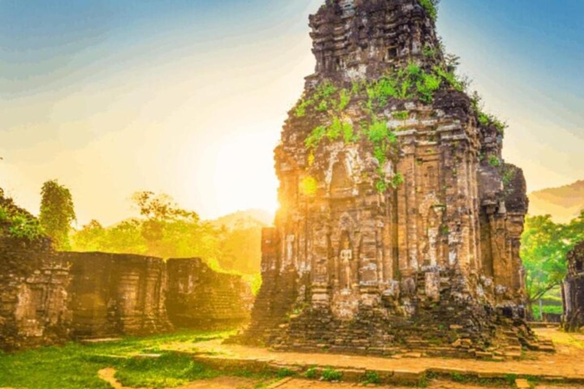 một tòa nhà bằng đá với mặt trời ở phía sau
