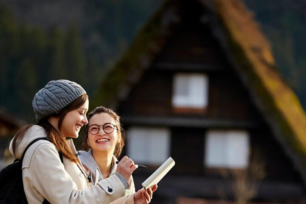due donne in piedi una accanto all'altra che guardano un cellulare