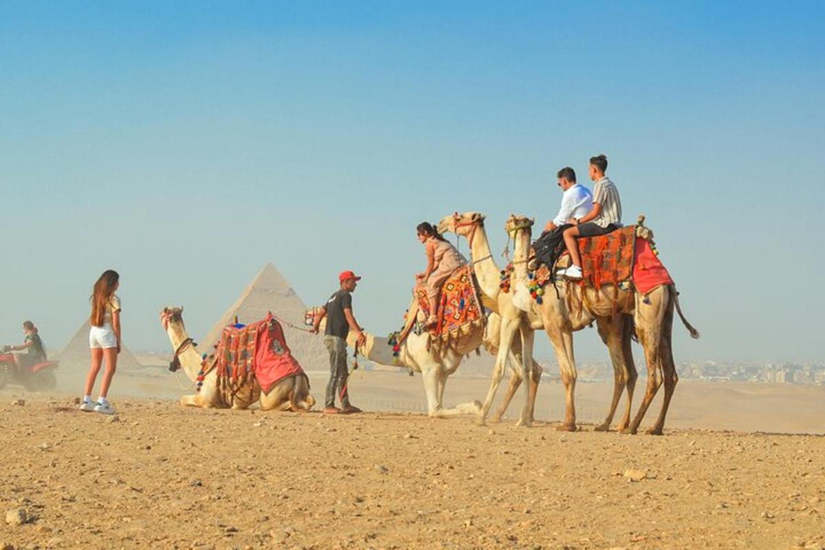 un gruppo di persone a cavallo di cammelli nel deserto