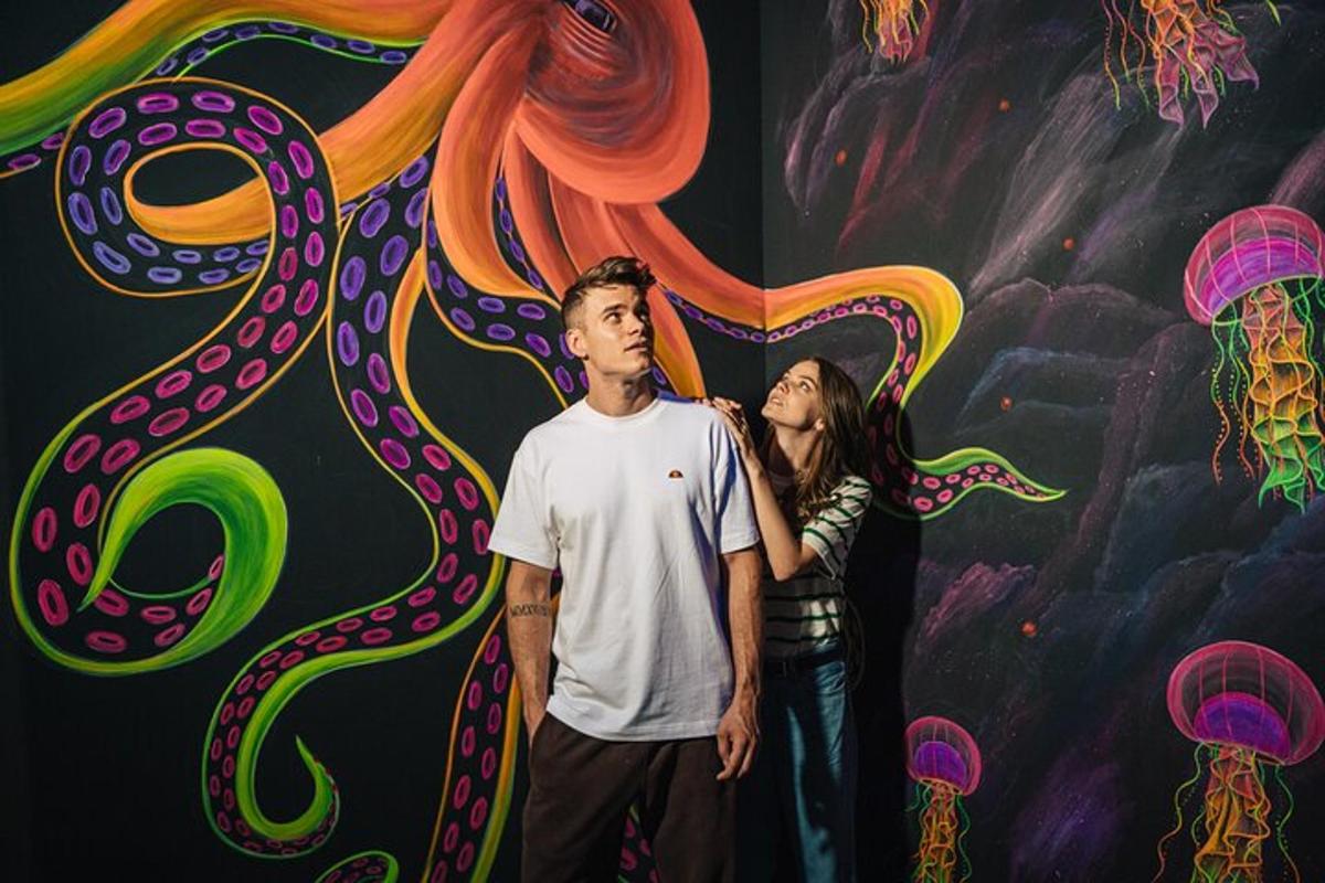 a man and a woman standing in front of a painting