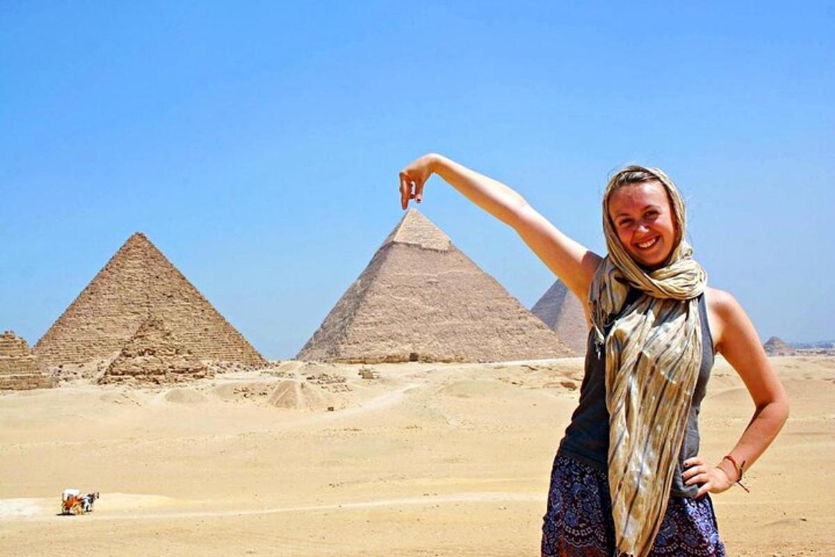 Žena stojí před pyramidami