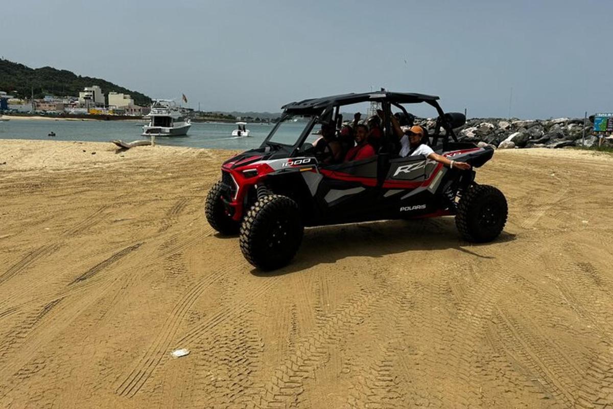 a group of people riding in a four wheeler on the beach
