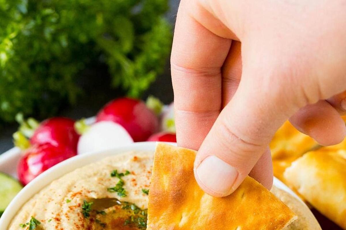 una persona che tiene un pezzo di cibo davanti a una ciotola di cibo