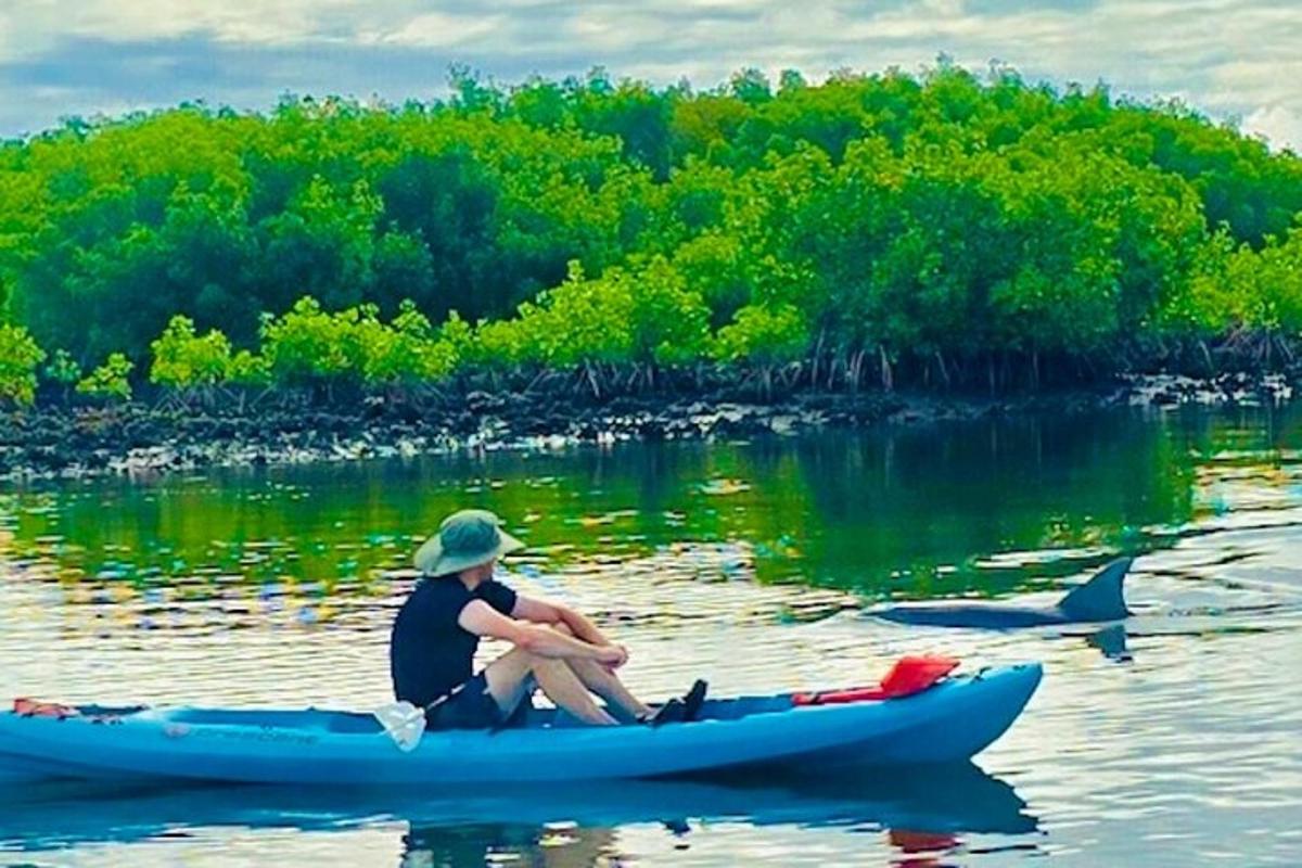 một người đàn ông đang ngồi trên thuyền kayak dưới nước