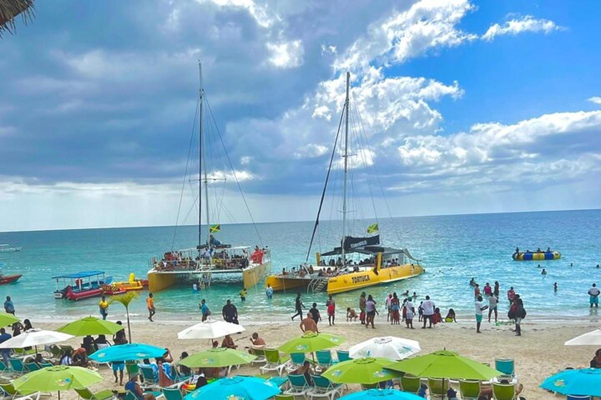 um grupo de pessoas em uma praia com barcos na água