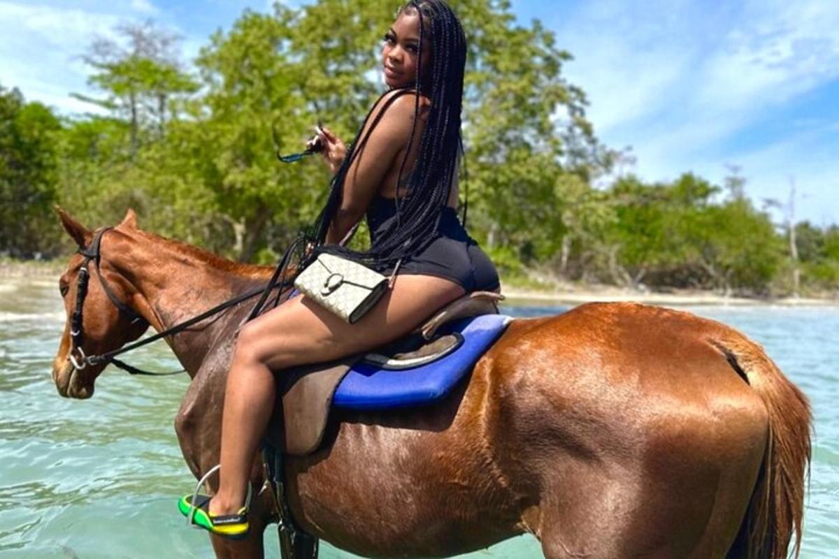 una donna seduta su un cavallo nell'acqua