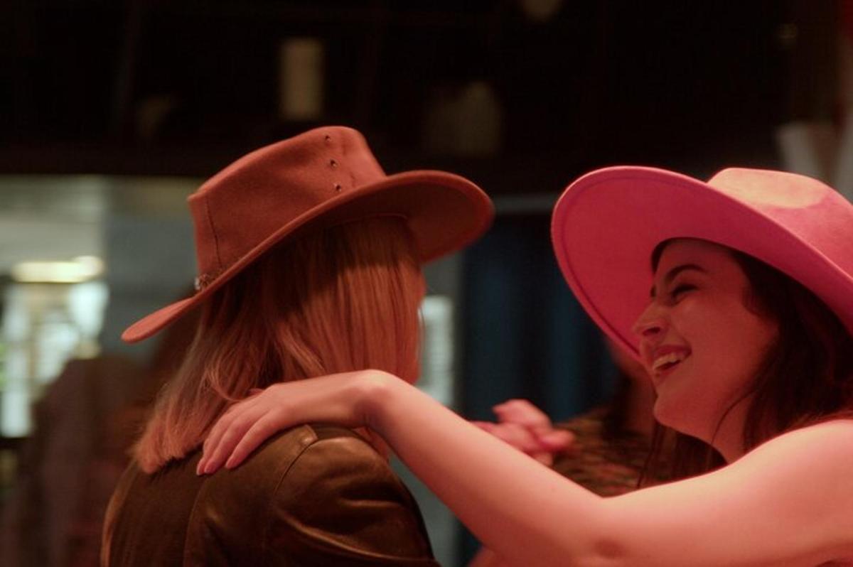 two women wearing hats sitting next to each other