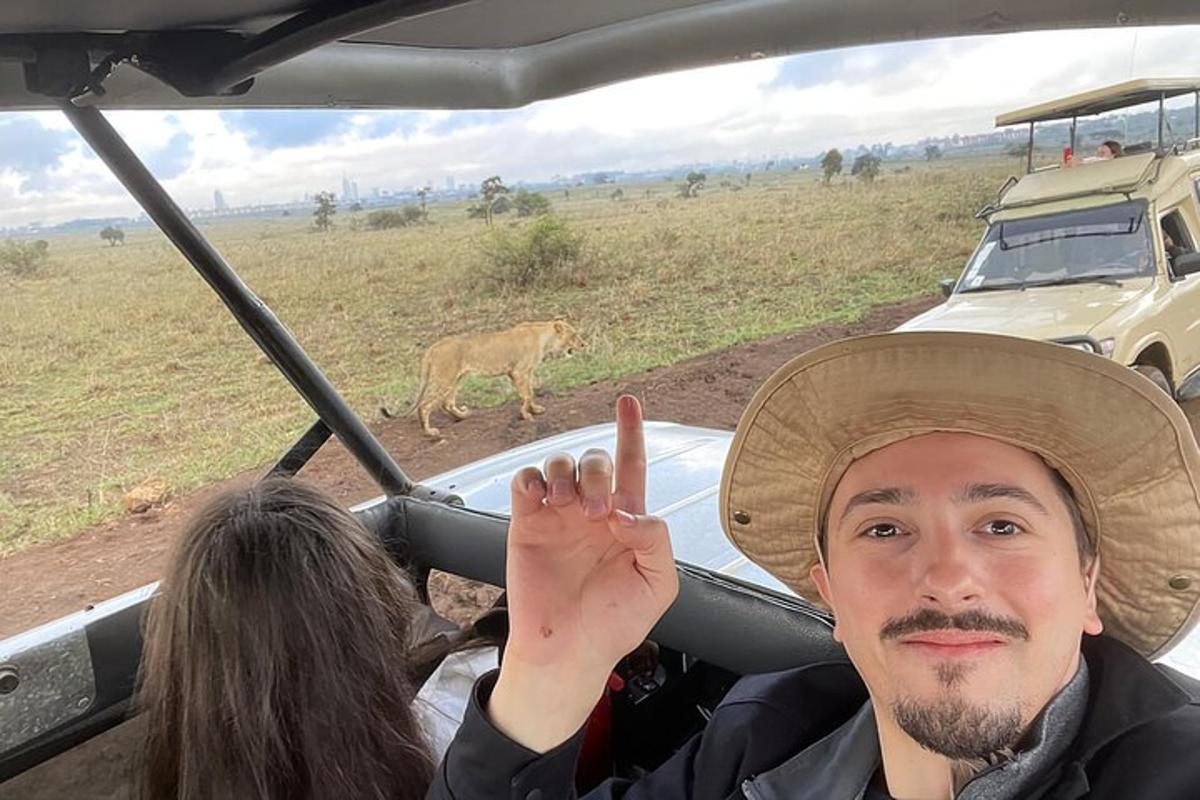 isang lalaking nakasumbrero na nagbibigay ng peace sign sa isang sasakyan