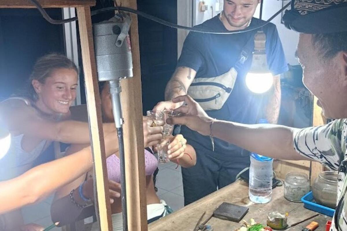 テーブルの周りに座ってワインを飲んでいる人々のグループ