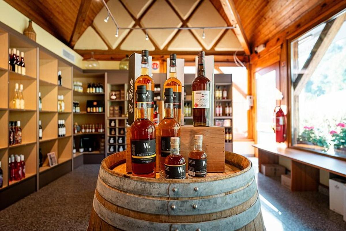 un mucchio di bottiglie di whisky su un barile in una stanza