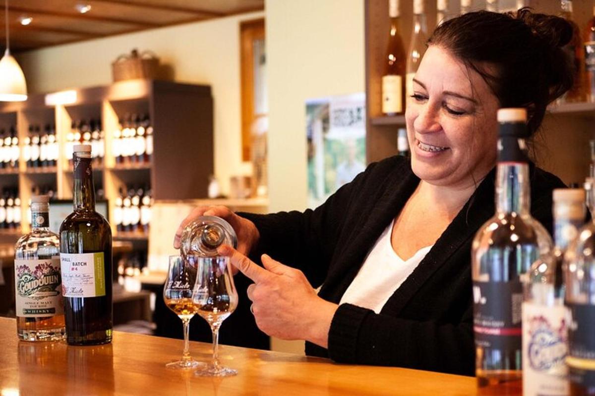 žena sediaca za barom a nalievajúca si pohár vína