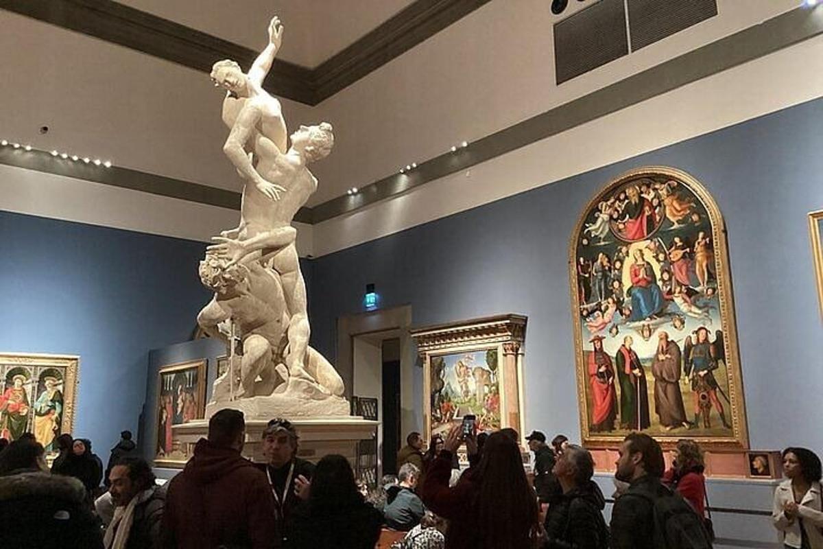 a crowd of people in a museum with a statue