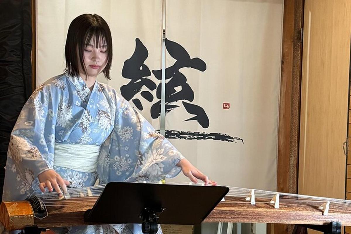 kimonos naine seisab laua taga sülearvutiga