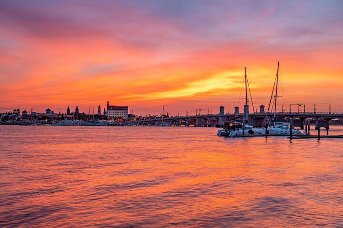 Un grupo de barcos en el agua al atardecer