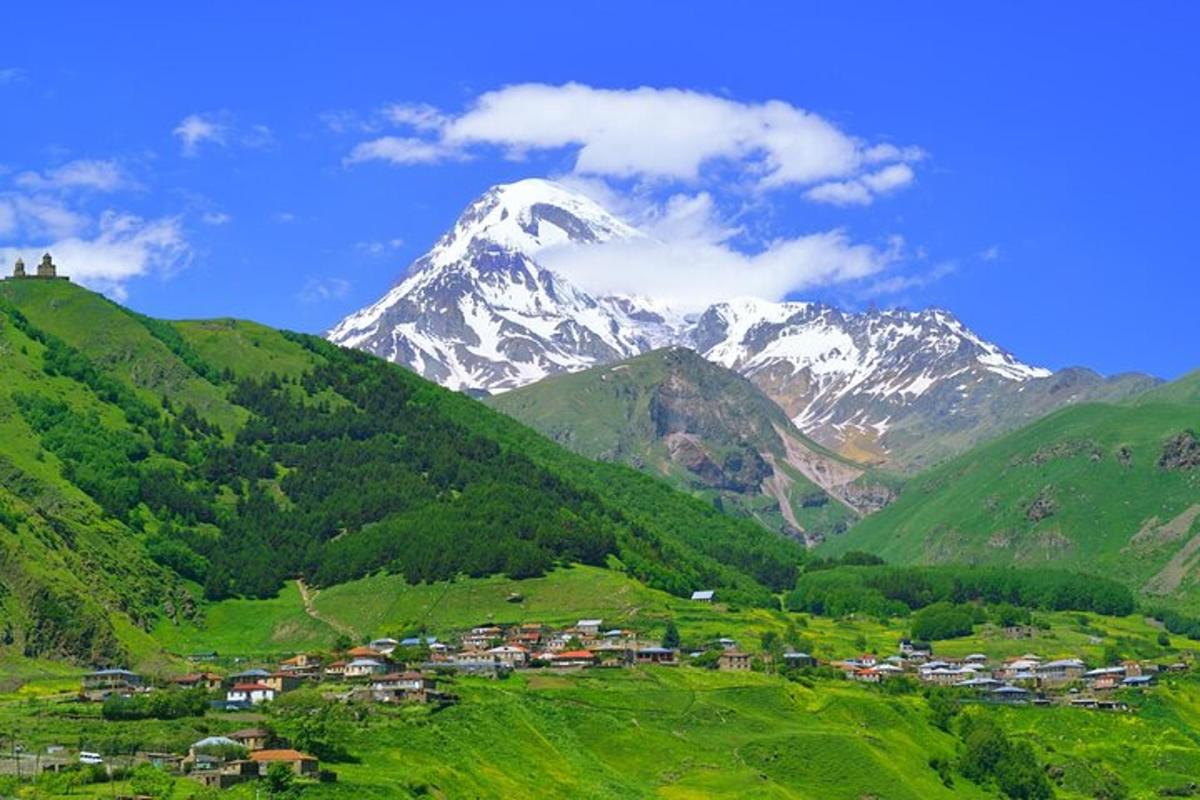 جبل مع قرية في وادٍ أخضر