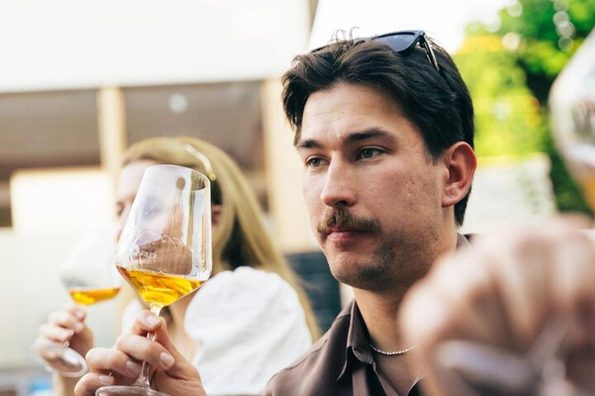 un uomo che tiene in mano un bicchiere di vino bianco