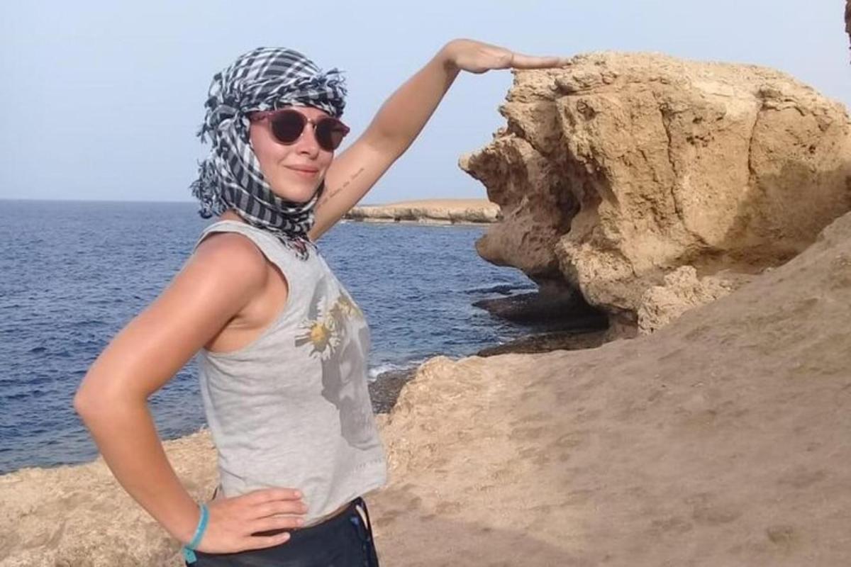 Una mujer parada sobre una roca cerca del agua