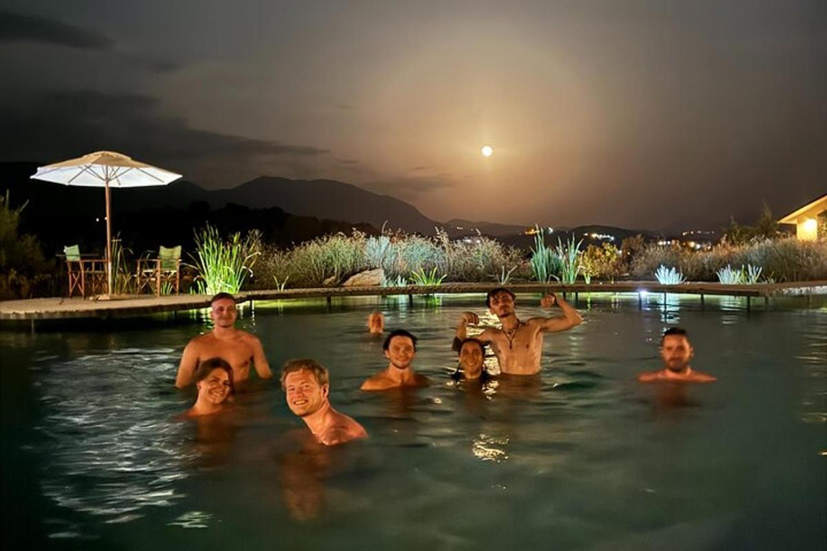 un grup de persones en una piscina a la nit