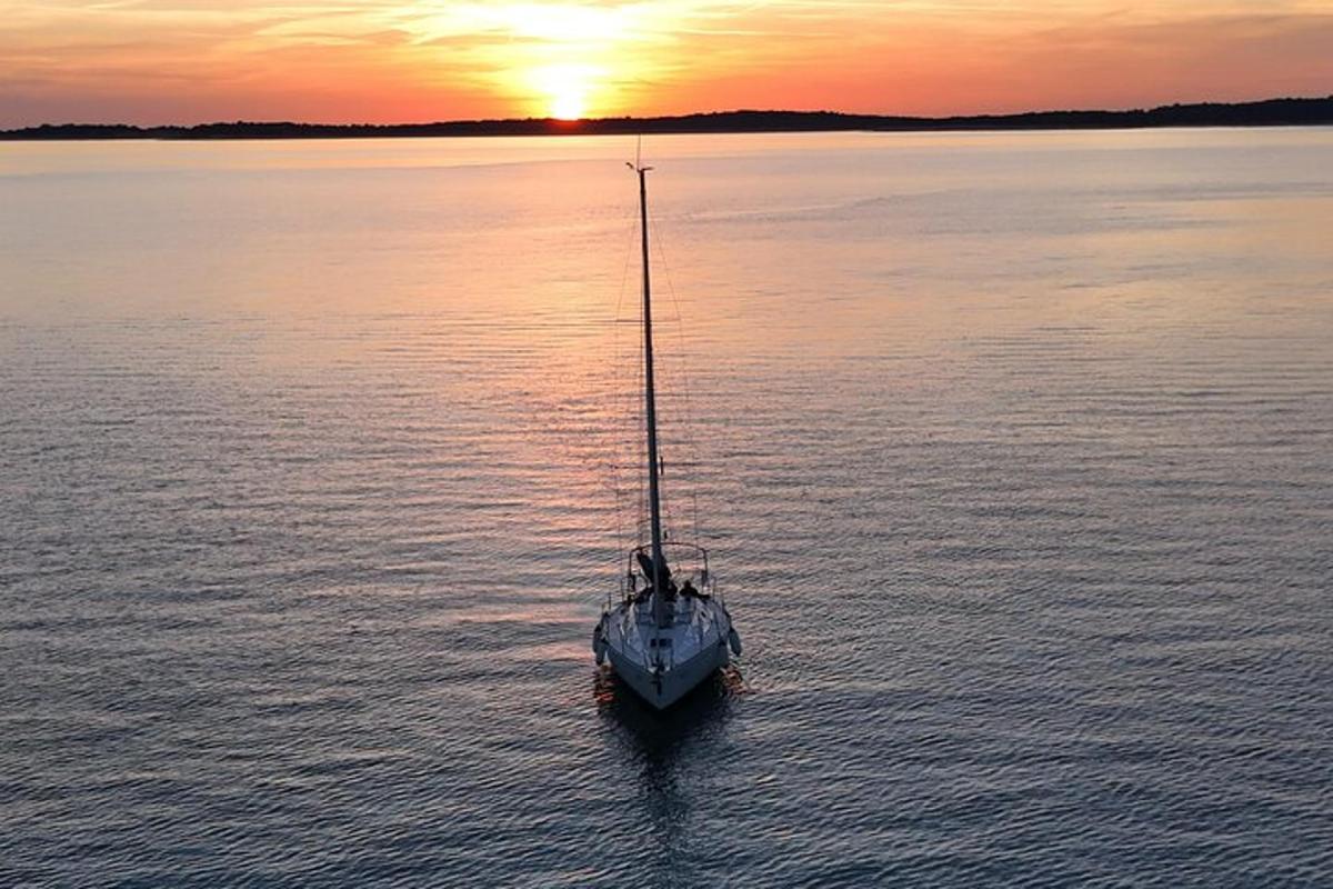 una barca in acqua con il tramonto sullo sfondo