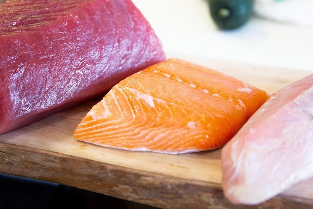 tatlong iba't ibang uri ng isda sa isang kahoy na cutting board