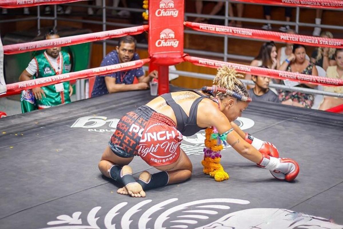 a woman laying on the ground in a boxing ring