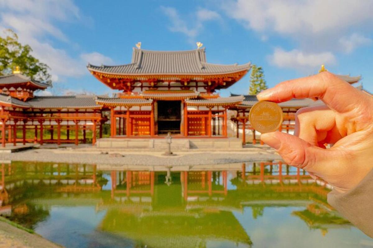 a person holding up a coin in front of a building