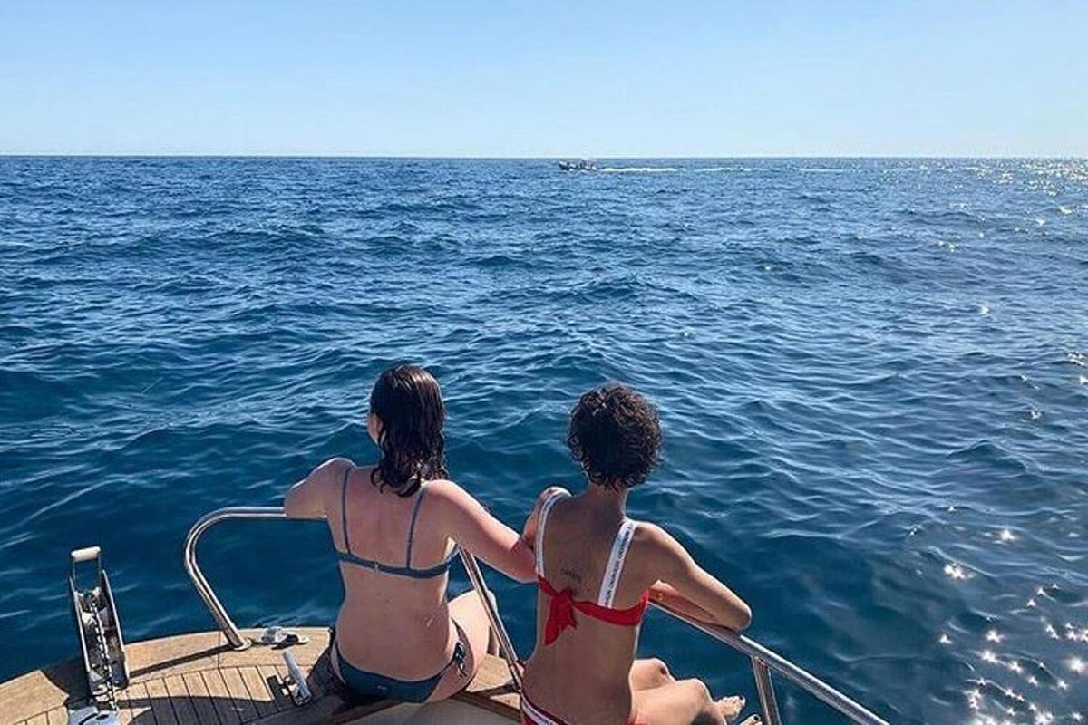 due donne in bikini sedute su una barca in acqua