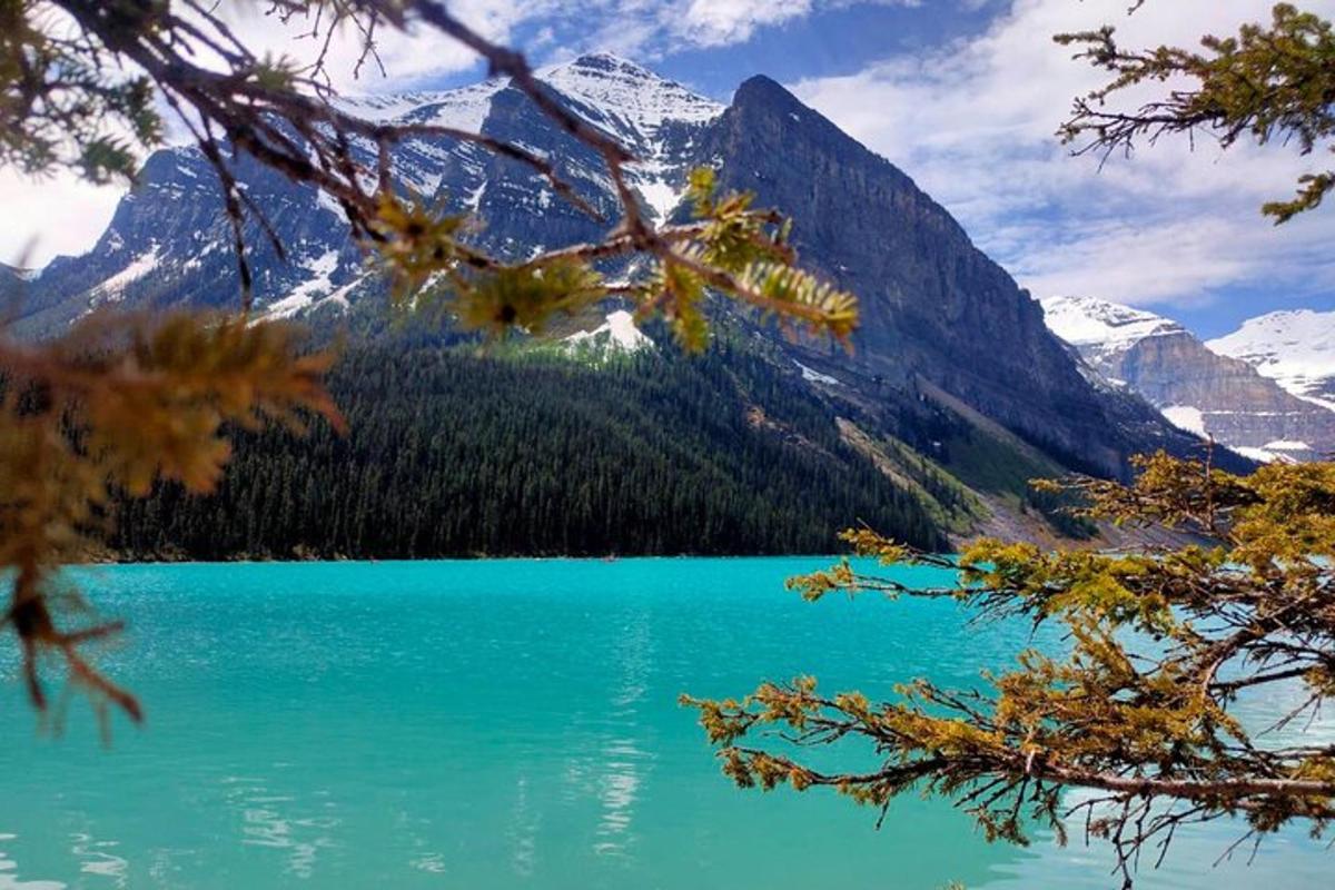 a blue lake with snow capped mountains in the background