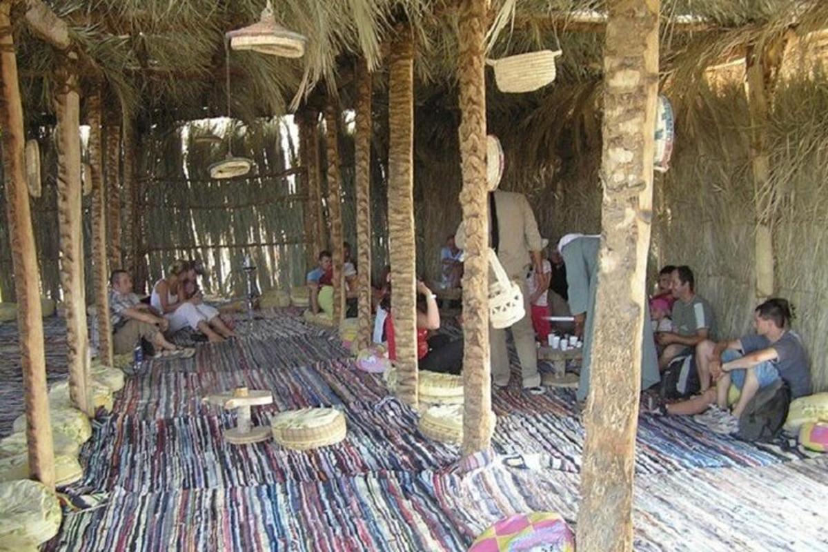 un gruppo di persone sedute in una stanza con delle palme