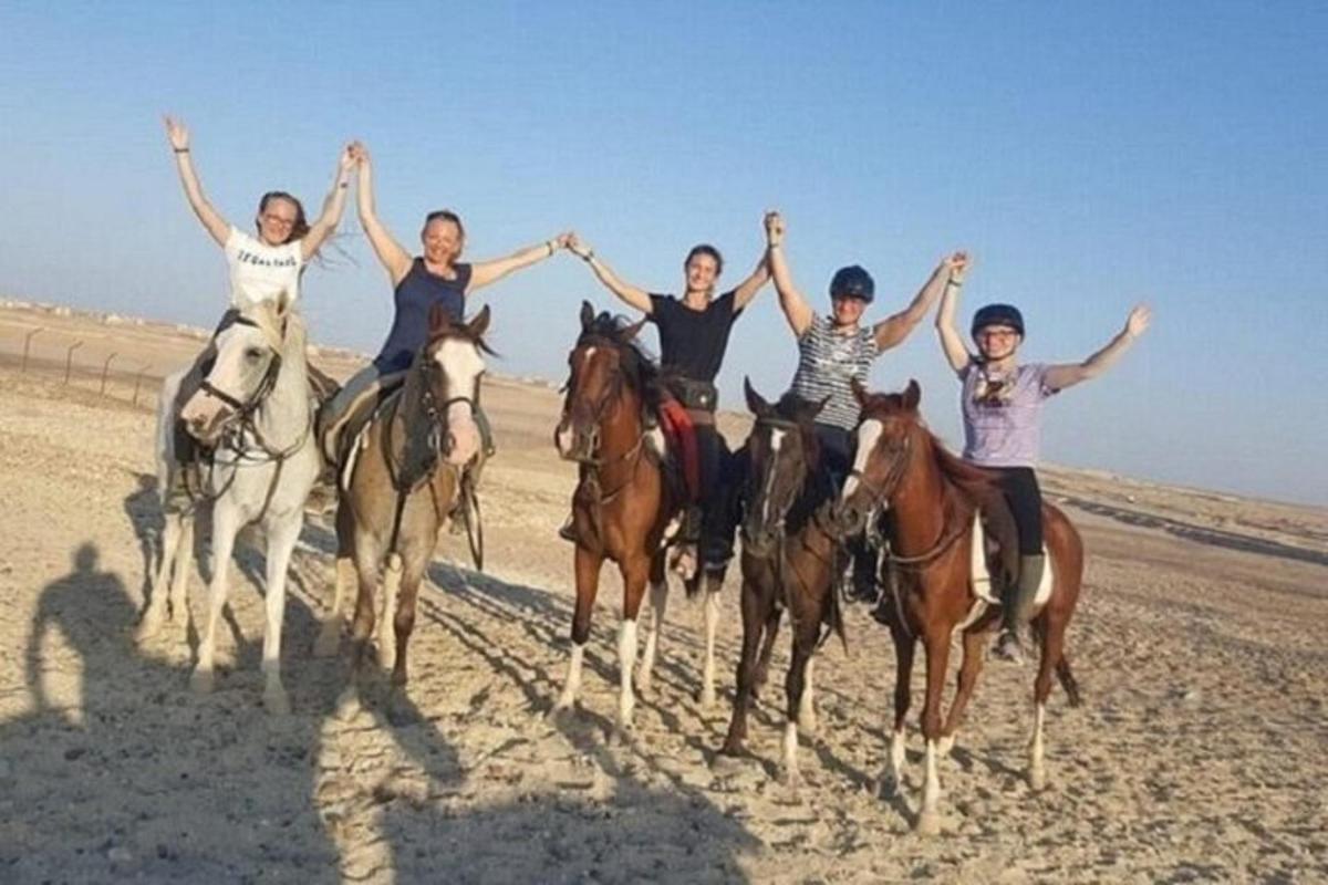 مجموعة من الناس يركبون الخيول في الصحراء