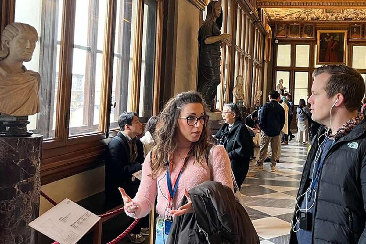 un grup de persones dretes en un museu mirant una estàtua