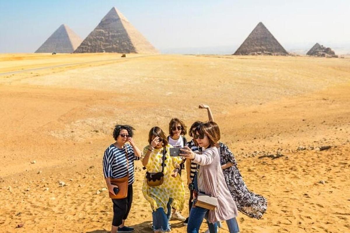 en gruppe mennesker står foran pyramiderne