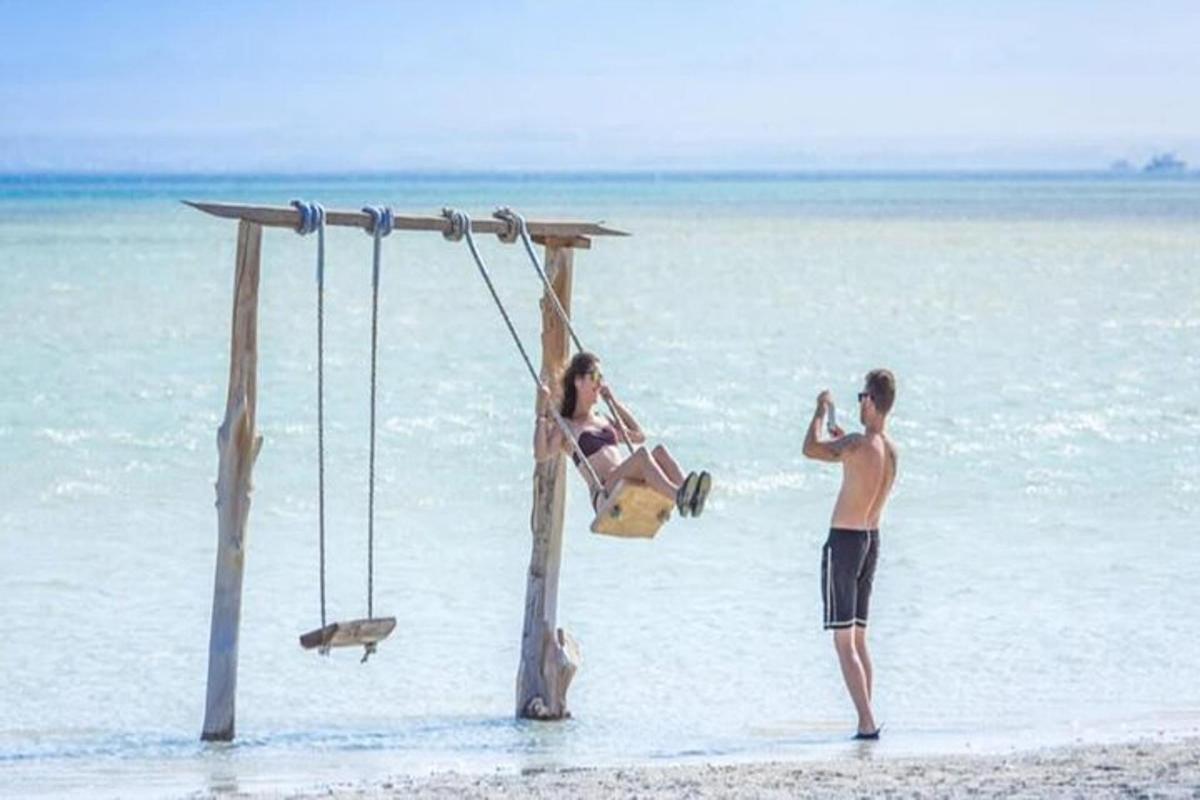 a man taking a picture of a woman on the beach