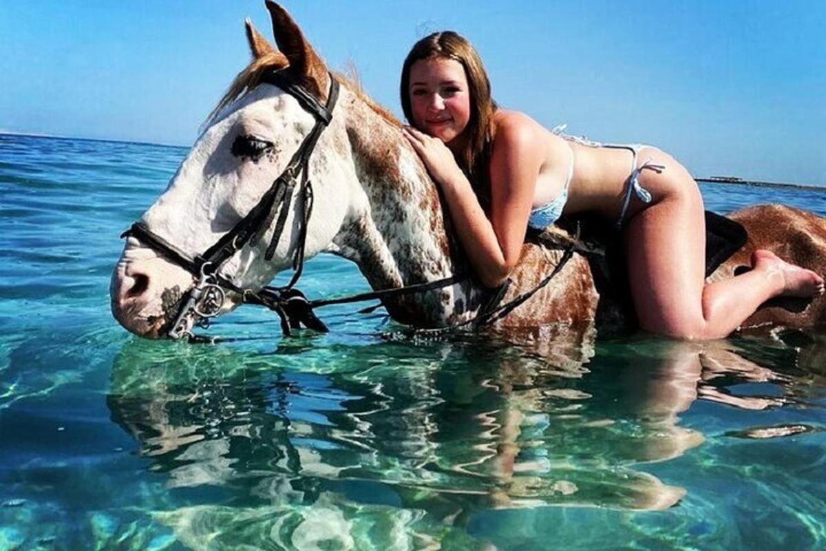 a girl riding a horse in the water
