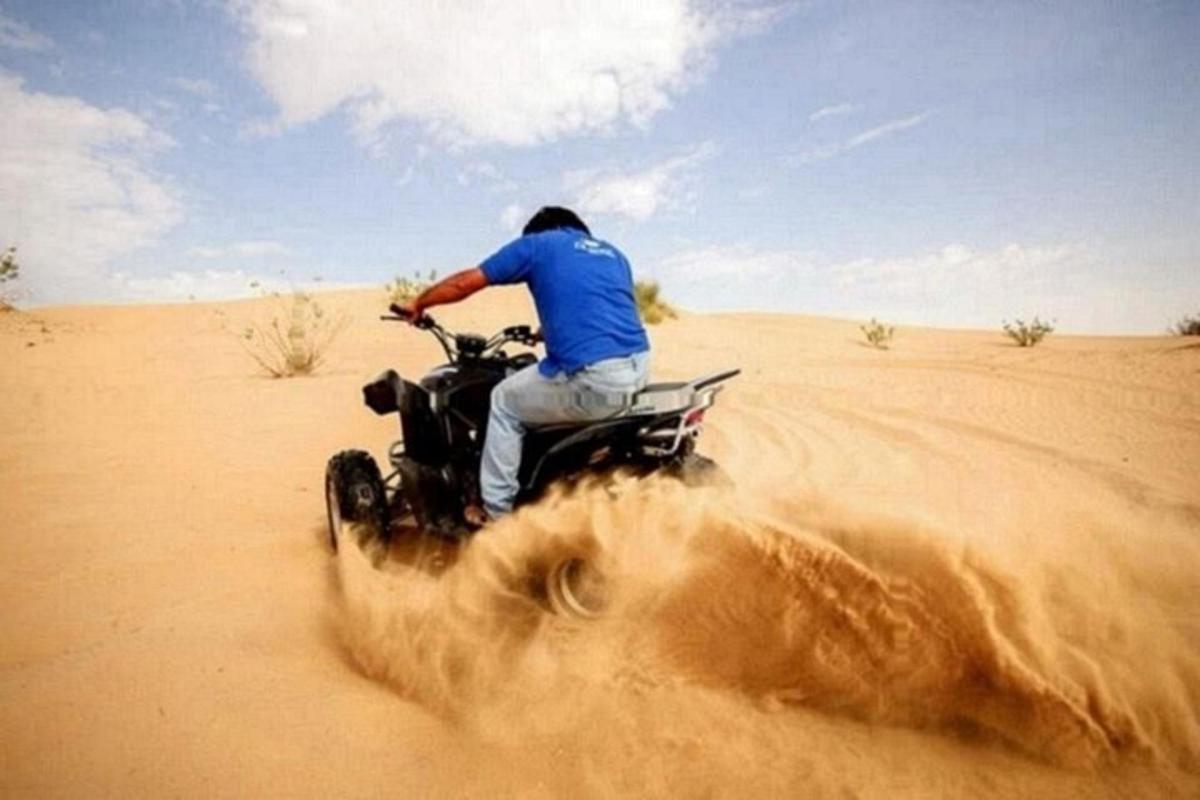 un uomo in sella a una moto da cross nel deserto