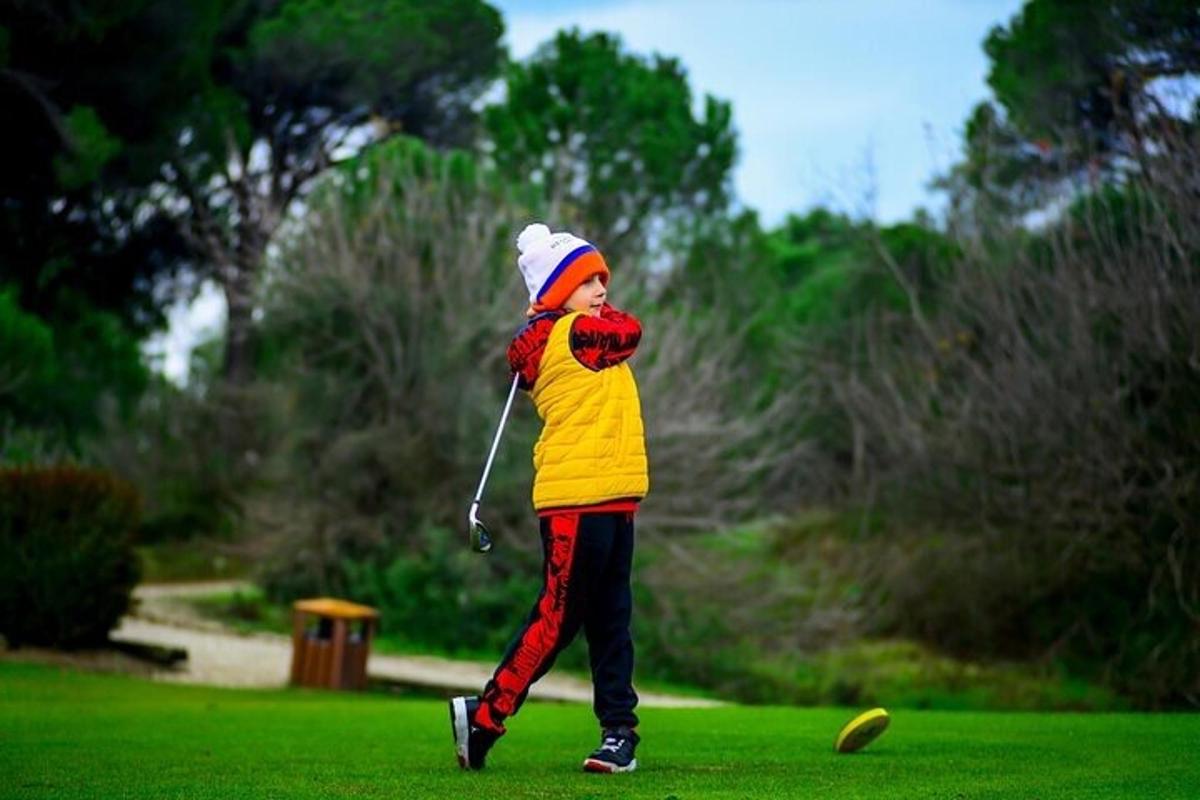 a young boy is playing golf in a park