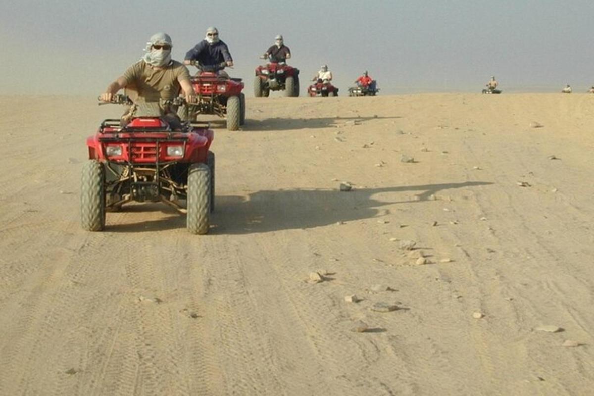 sekumpulan orang menunggang atv di padang pasir