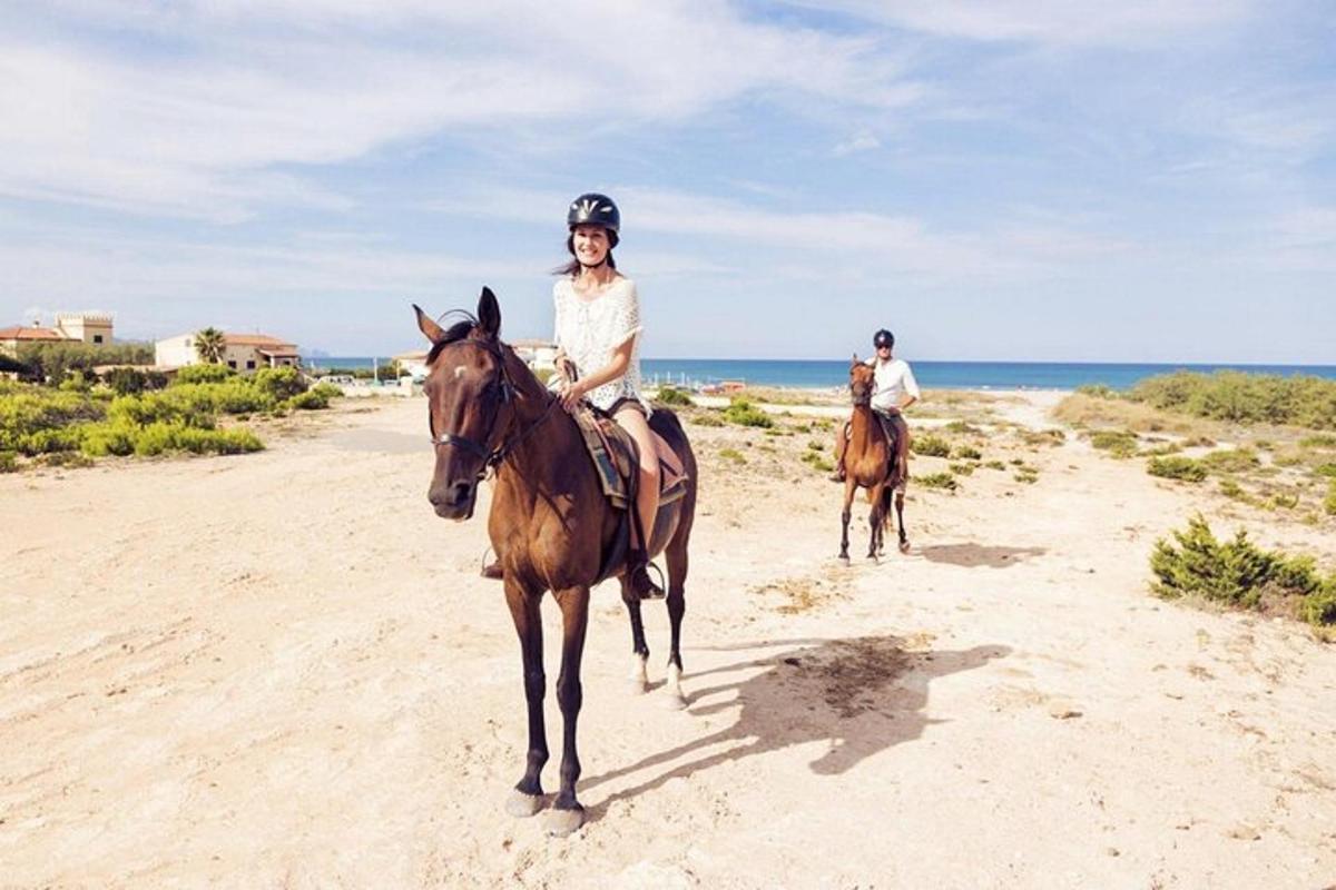 zwei Personen reiten am Strand