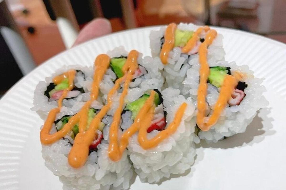 isang puting plato ng sushi na may kasamang orange sauce