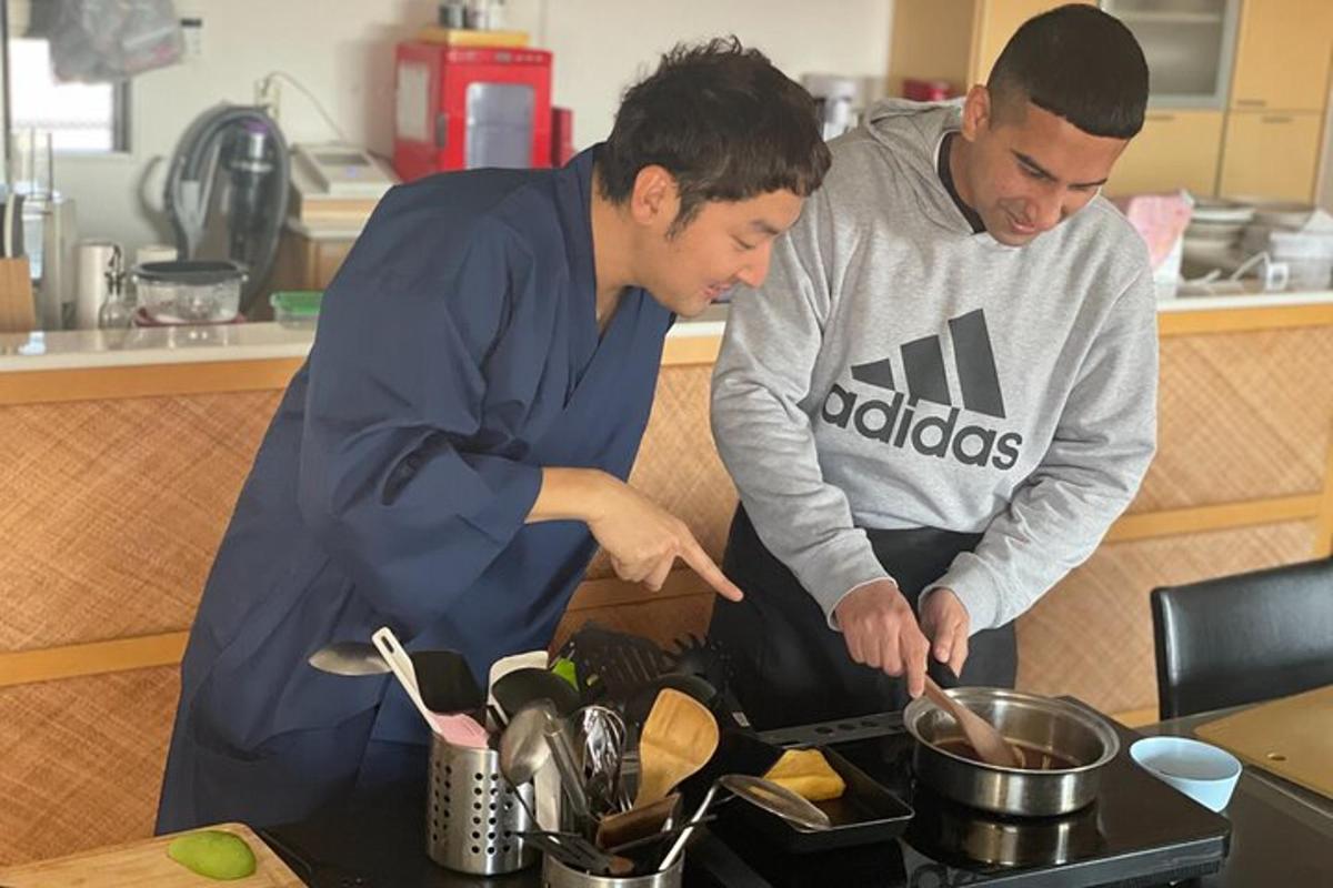 dua lelaki di dapur menyediakan makanan di atas dapur