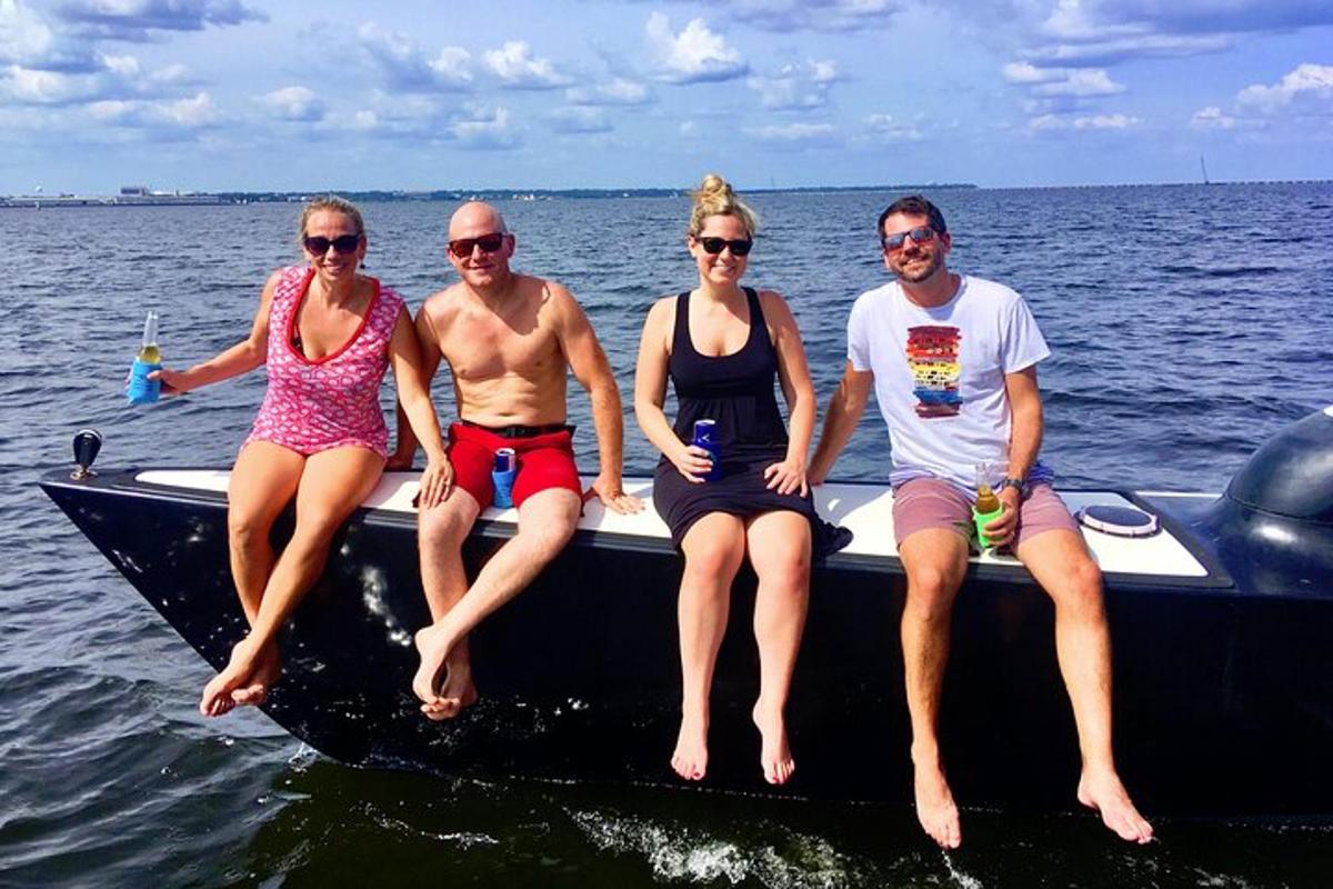 four people sitting on a boat in the water