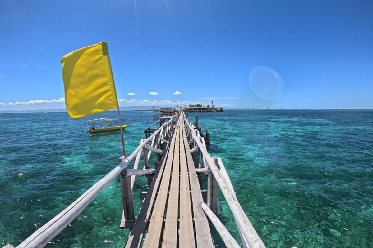 a wooden pier in the ocean with a yellow flag