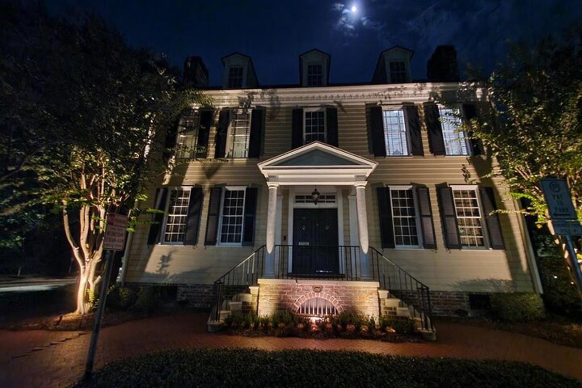 a large white house with a porch at night