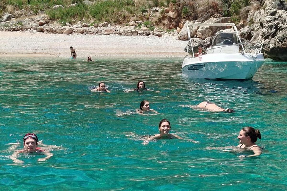 sekumpulan orang berenang di dalam air berhampiran bot