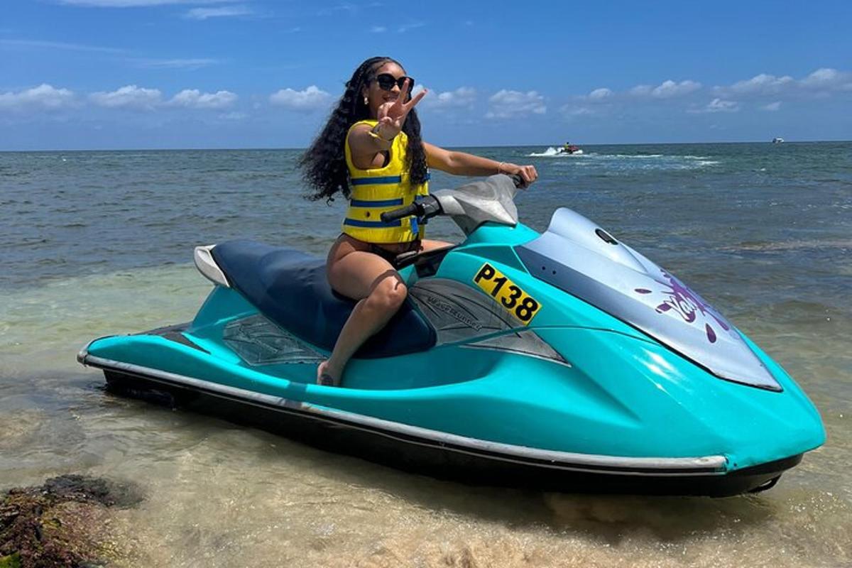 Žena sjedi na jet skiju na plaži