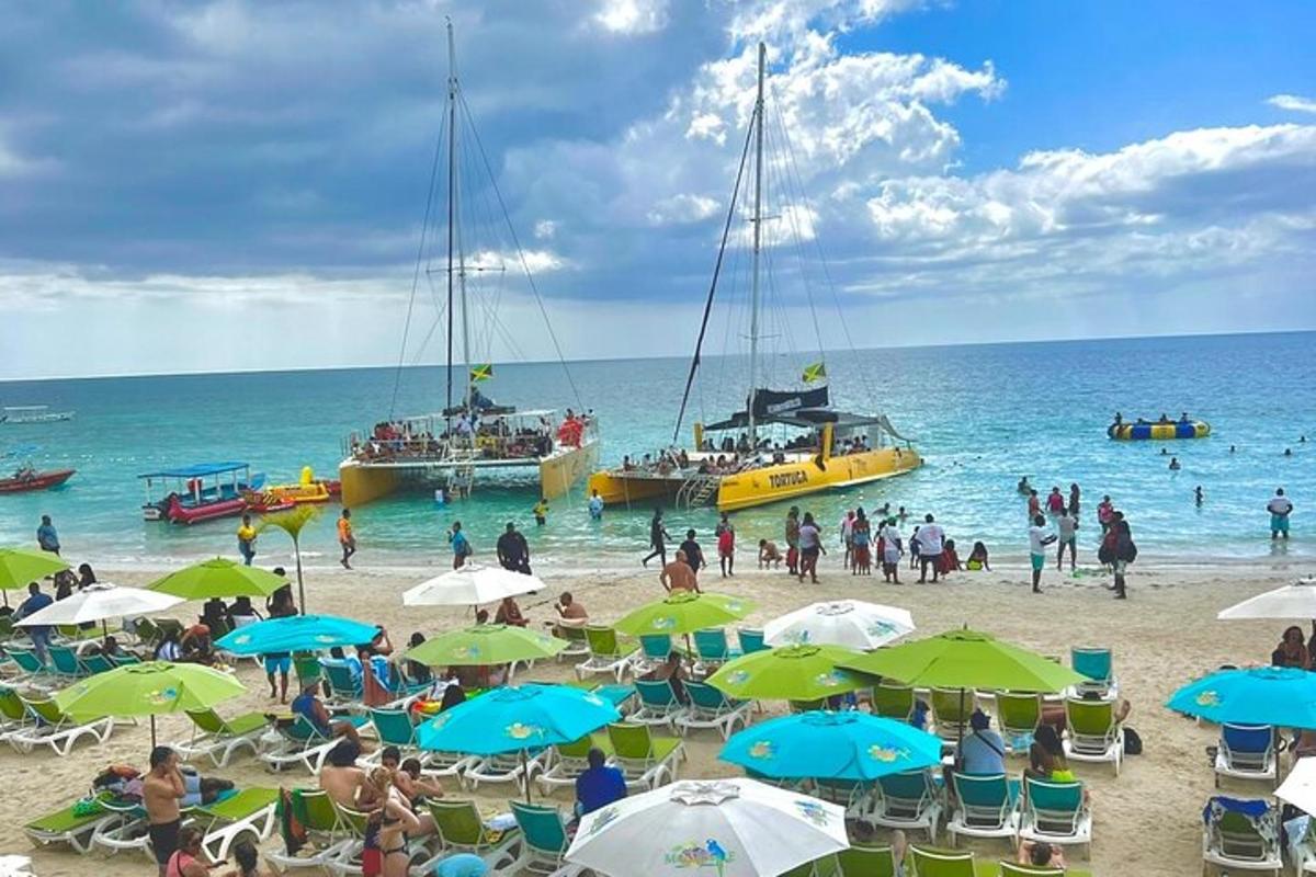 sekelompok orang di pantai dengan perahu di air