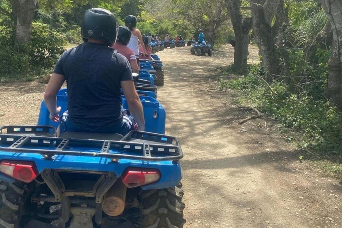 um grupo de pessoas andando de quadriciclo em uma estrada de terra