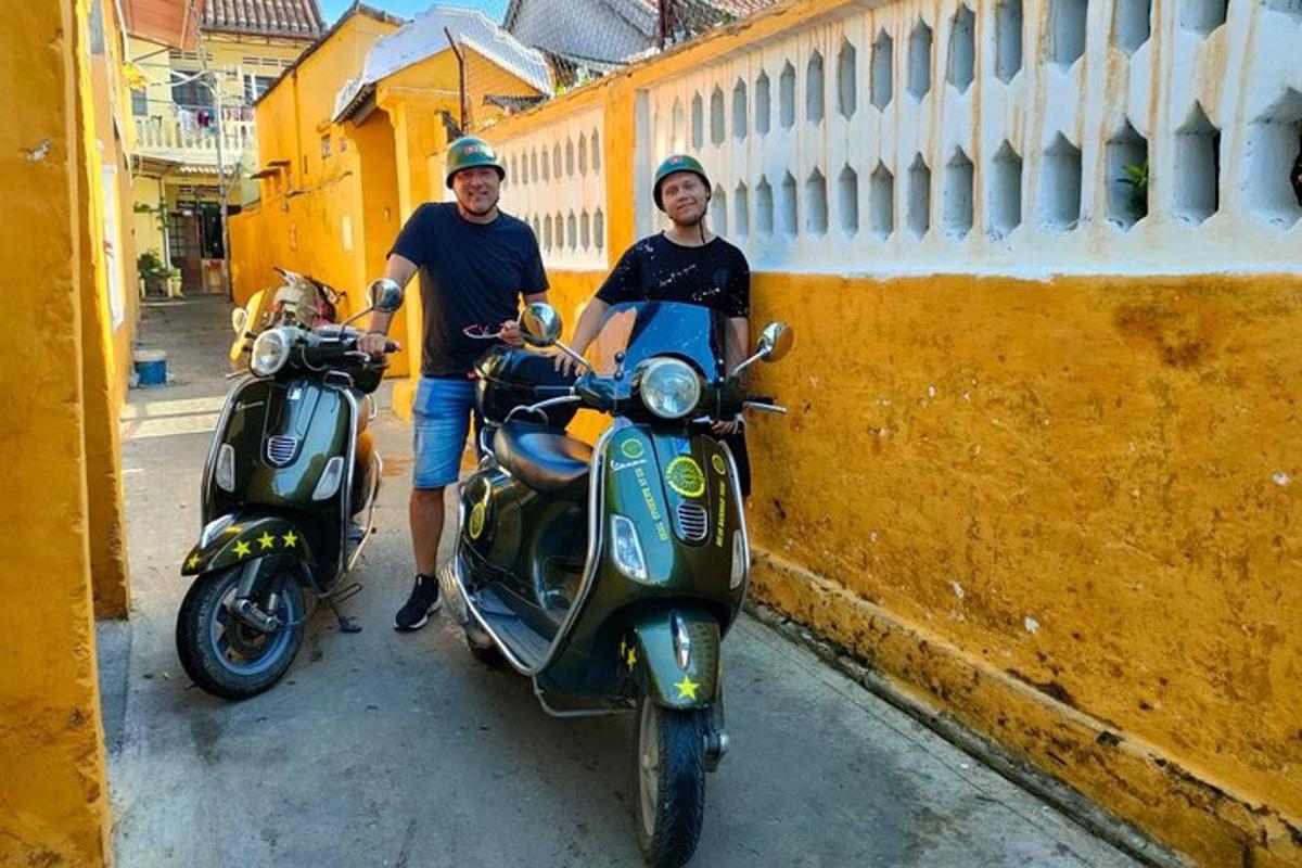 seorang lelaki berdiri di sebelah sebuah motor skuter