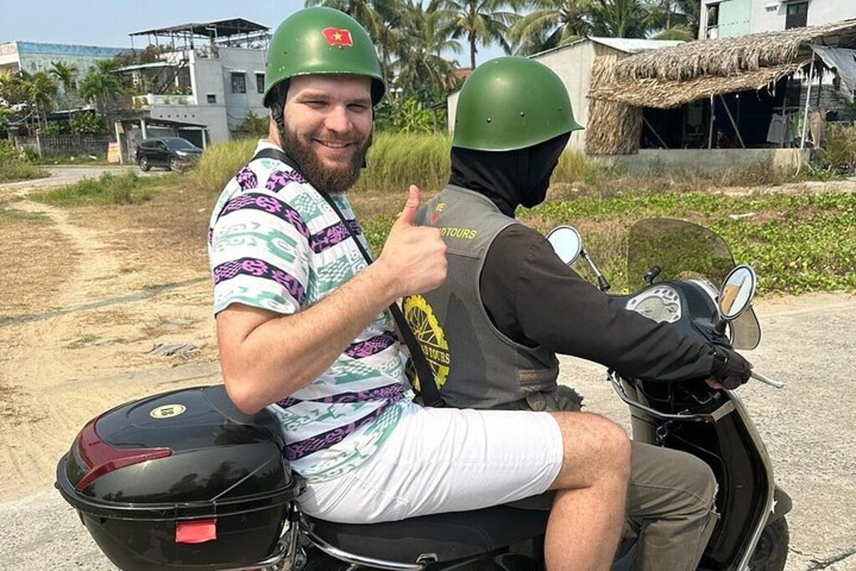 seorang lelaki menunggang motosikal dengan seorang lelaki memberikan ibu jari
