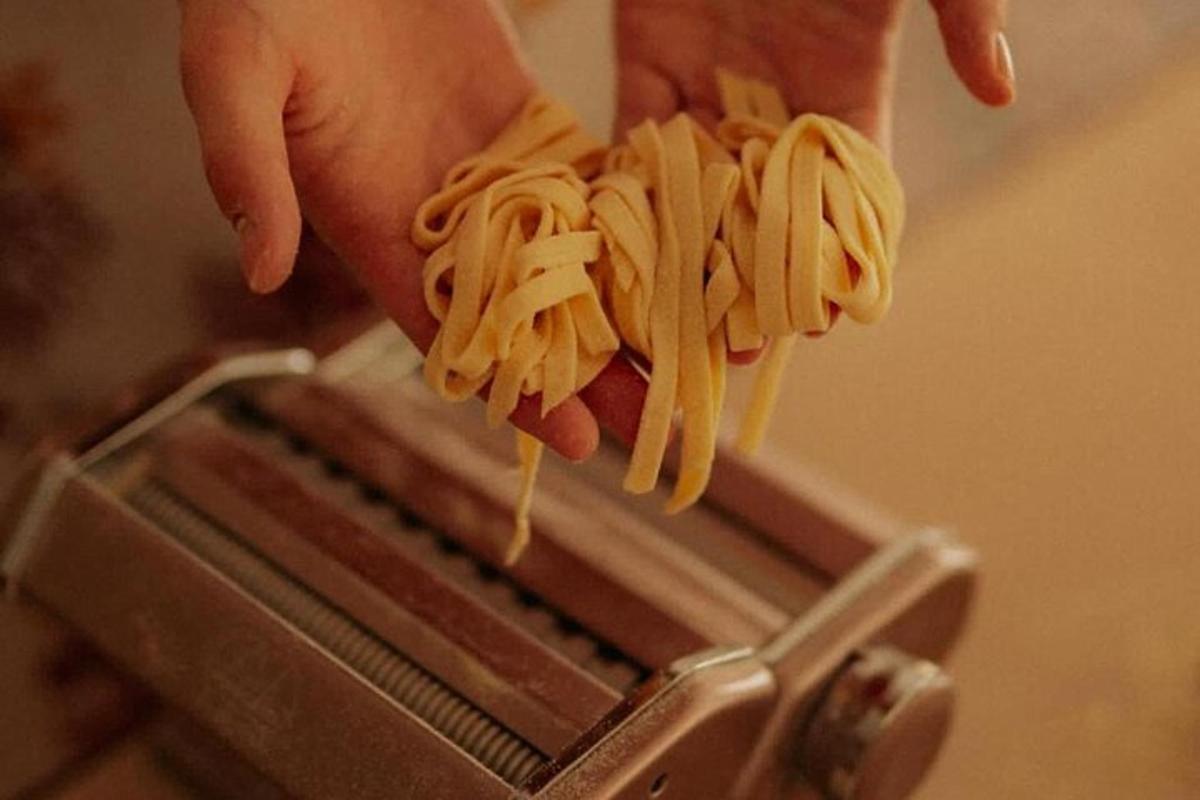 en person som holder et stykke pasta i en brødrister